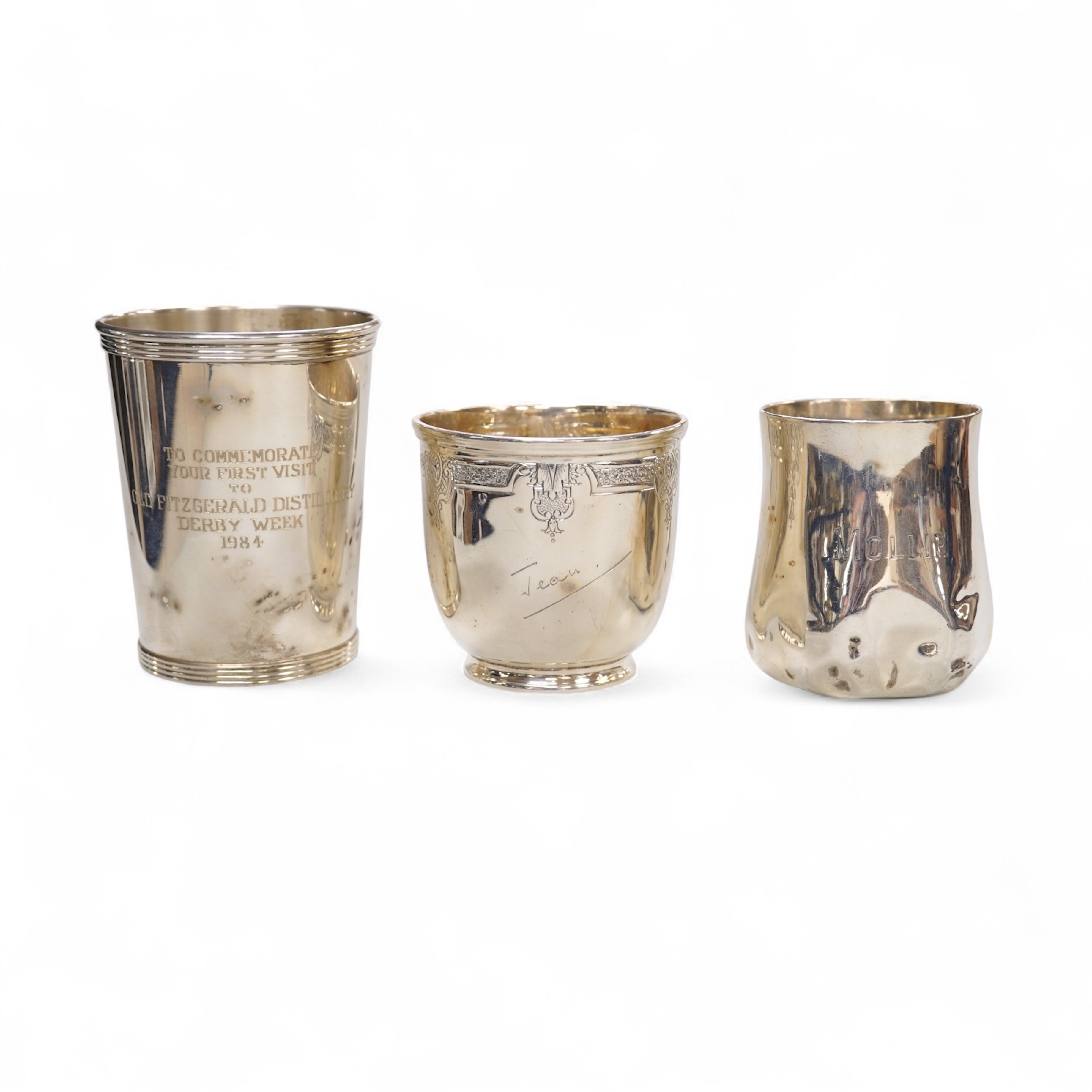 A George V engraved silver tea cup by Mappin & Webb, London, 1924, height 69mm, together with a Gorham sterling beaker and an Edwardian silver christening mug, 11oz.